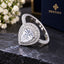 Silver-Tone Large Pear Cut CZ Triple Micro-Pavé Halo & Full Eternity Pavé Band Bridal Statement Ring on dark slate surface with white flowers and Destiny navy jewelry box in background