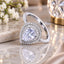 Silver-Tone Large Pear Cut CZ Triple Micro-Pavé Halo & Full Eternity Pavé Band Bridal Statement Ring on white marble surface with white flowers, cream silk fabric and gold crystal candleholder in background
