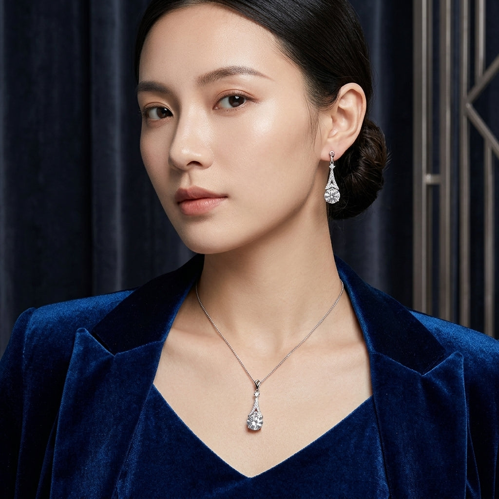 Silver-Tone Large Round Brilliant CZ Solitaire & Pavé Teardrop Cap Pendant Necklace & Drop Earrings Jewelry Set worn on model in blue velvet blazer with dark navy backdrop in luxury editorial setting