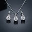 Silver-Tone Large Round Brilliant CZ Solitaire & Pavé Teardrop Cap Pendant Necklace & Drop Earrings Jewelry Set flat lay on dark reflective surface showing pendant and matching drop earrings