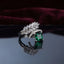 Silver Marquise Leaf Crown Princess CZ Adjustable Cocktail Ring in Emerald Green — rhodium-plated open adjustable ring with marquise white CZ leaf crown, micro-pavé arc, and deep emerald green princess cut center stone, on dark mirror with burgundy velvet backdrop