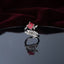 Silver Marquise Leaf Crown Princess CZ Adjustable Cocktail Ring in Ruby Red — rhodium-plated open adjustable ring with marquise white CZ leaf crown, micro-pavé arc, and deep ruby crimson red princess cut center stone, on dark mirror with burgundy velvet backdrop