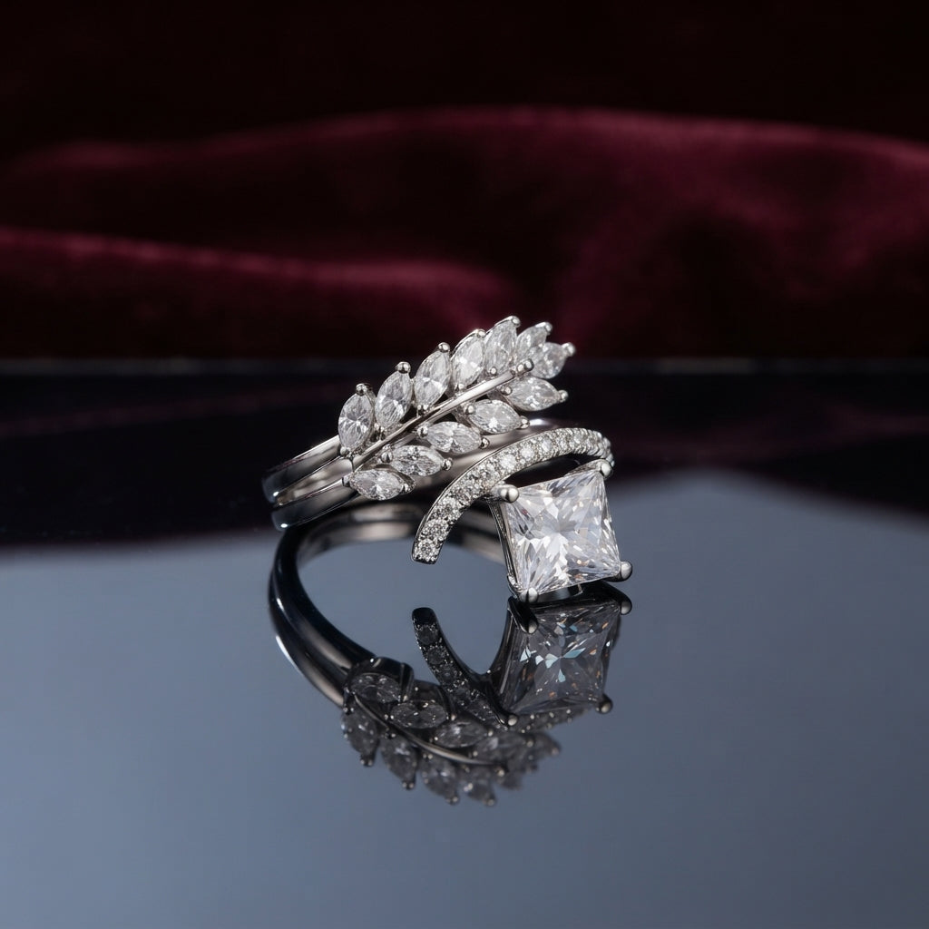 Silver Marquise Leaf Crown Princess CZ Adjustable Cocktail Ring in White Diamond — rhodium-plated open adjustable ring with marquise white CZ leaf crown, micro-pavé arc, and brilliant clear white diamond-illusion princess cut center stone, on dark mirror with burgundy velvet backdrop