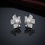 Silver-Tone Micro-Pavé CZ Orchid Flower Pearl Center Statement Stud Earrings on dark mirror surface with deep burgundy velvet backdrop
