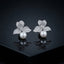 Silver-Tone Micro-Pavé CZ Triple Leaf Flower Cap & South Sea Pearl Stud Earrings on black mirror surface with dark background