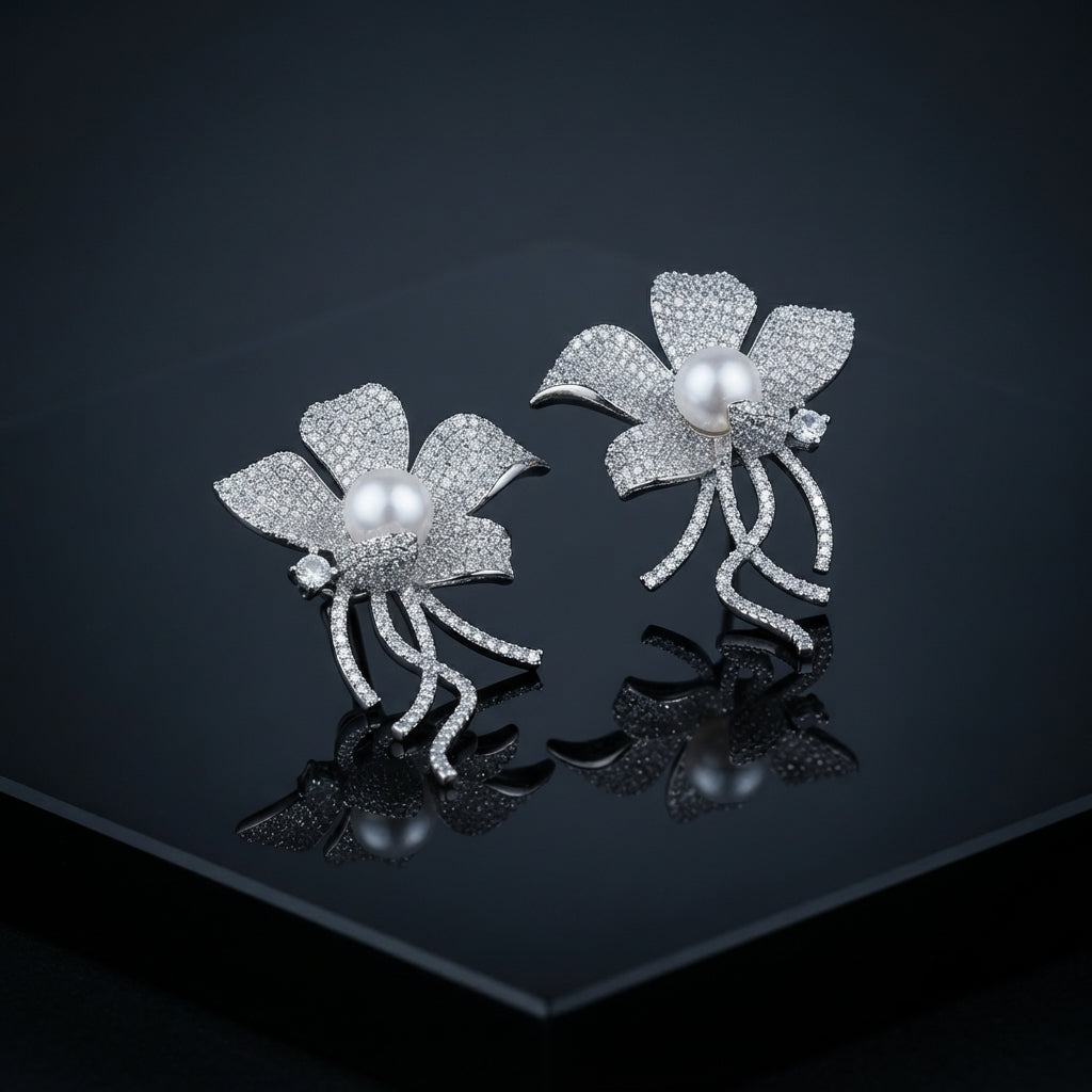 Silver-Tone Micro-Pavé CZ Wild Orchid Pearl Center & Pavé Tendril Stem Statement Earrings on black mirror surface with dark background