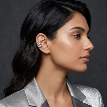 Silver-Tone Multi-Row Crossover Pavé White CZ Huggie Hoop Ear Cuff Earrings worn on right ear of South Asian female model in silver blazer with dark grey studio backdrop