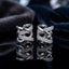 Silver-Tone Multi-Row Crossover Pavé White CZ Huggie Hoop Ear Cuff Earrings pair on black reflective surface with navy blue velvet fabric backdrop