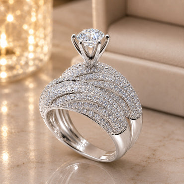 Silver-Tone Multi-Row Dome Pavé White CZ Cathedral Solitaire Bridal Ring on marble surface with gold bokeh lantern backdrop