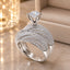Silver-Tone Multi-Row Dome Pavé White CZ Cathedral Solitaire Bridal Ring on marble surface with gold bokeh lantern backdrop