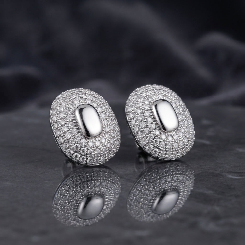 Gold-tone oval pavé stud earrings with smooth oval centers.