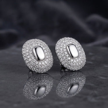 Gold-tone oval pavé stud earrings with smooth oval centers.