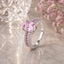 Silver-Tone Oval Pink CZ Solitaire Baguette & Pavé Double Shoulder Engagement Ring on blush marble surface with crystal bokeh light orb and pink baby’s breath flowers backdrop