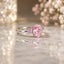 Silver-Tone Oval Pink CZ Three-Stone Solitaire Cocktail Ring on marble surface with bokeh pearl flower backdrop