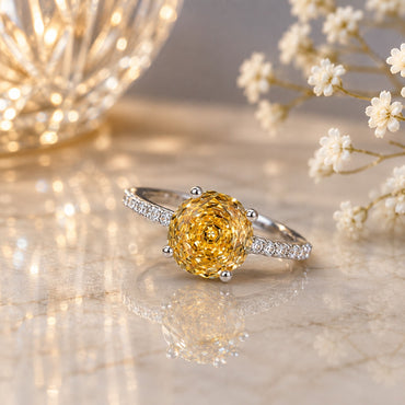 Silver-Tone Oversized Round Citrine Yellow CZ Rose-Cut Solitaire Ring with Pavé White CZ Band on marble surface with gold starburst ornament and baby's breath flowers backdrop