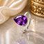 Silver-Tone Pear-Cut Amethyst CZ Solitaire Adjustable Cocktail Ring on cream marble surface with ivory satin fabric and gold Mughal decorative urn backdrop