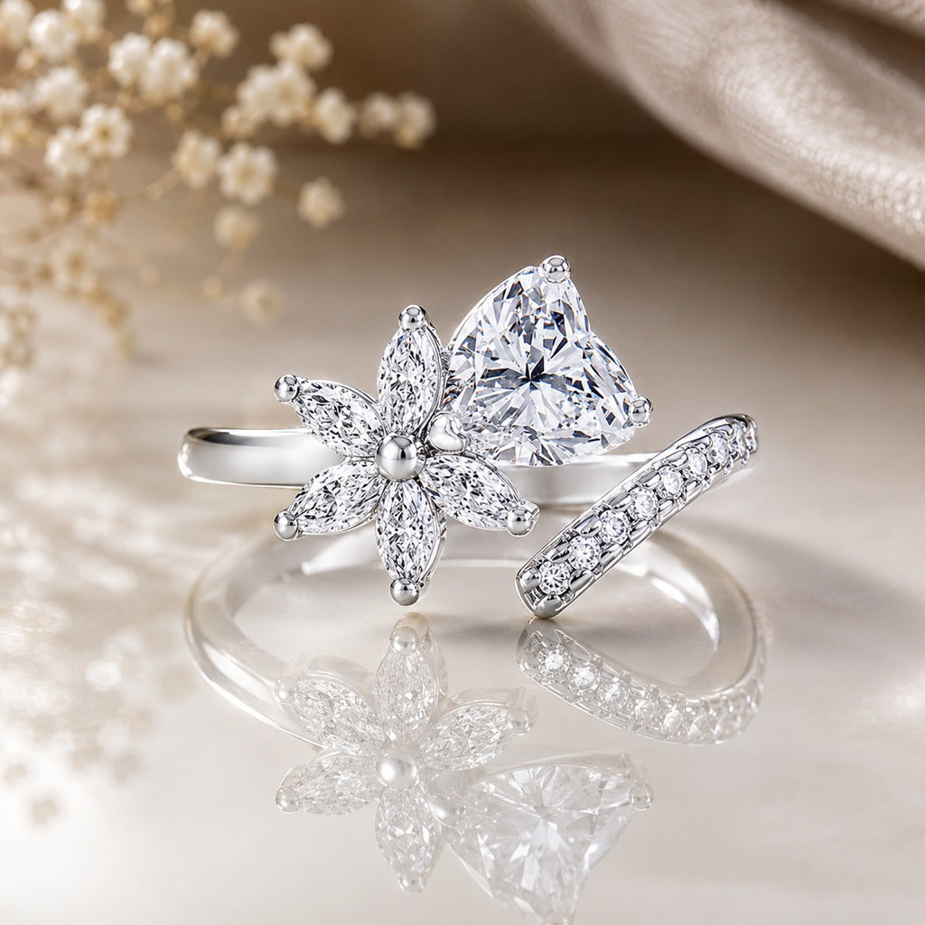 Silver-Tone Pear Cut White CZ Solitaire & Marquise Flower Open Cocktail Ring on reflective surface with pearl strands and blush silk backdrop