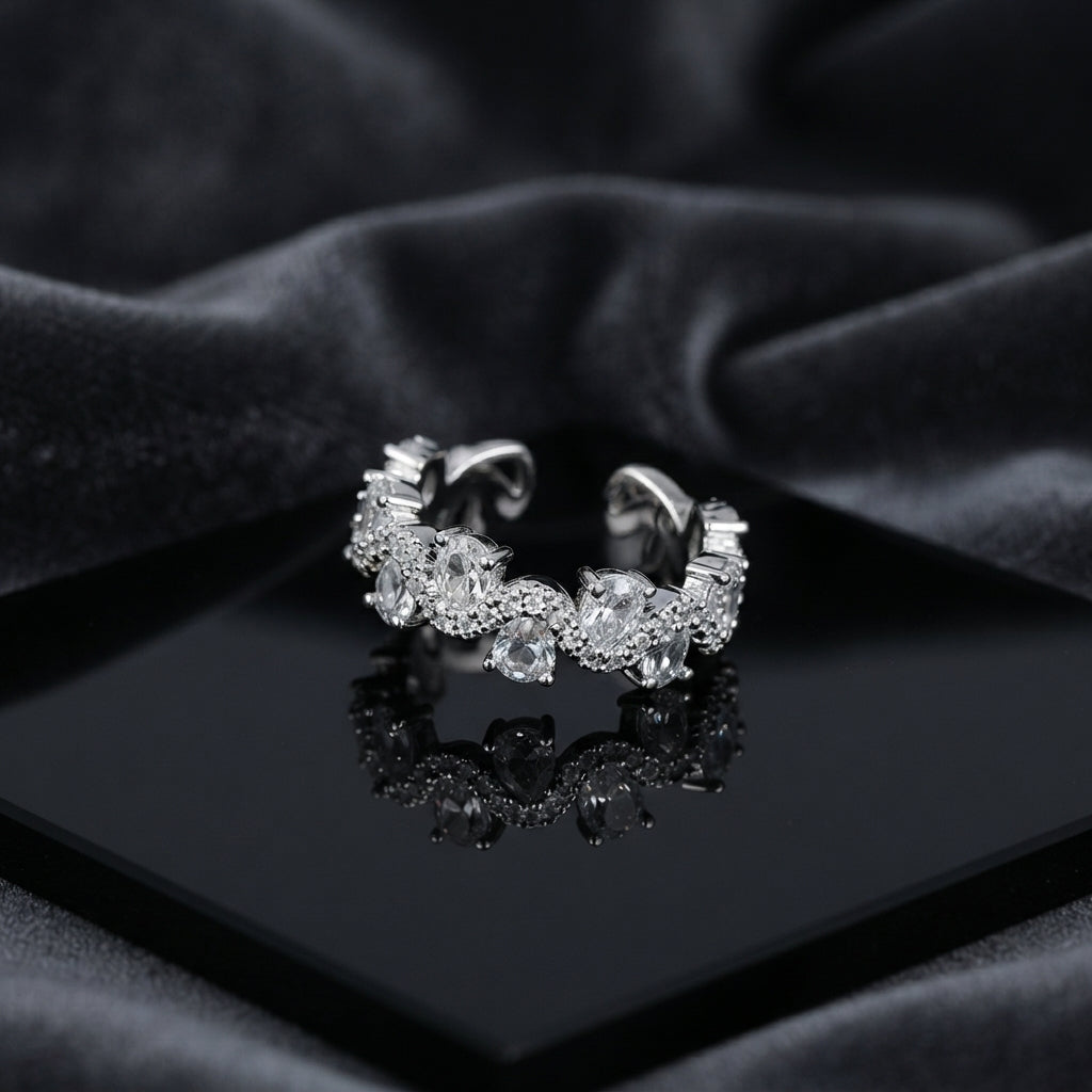 Silver Pear Rose-Cut CZ Eternity Wave Open Band Ring on black lacquer tray with dark grey satin drape backdrop