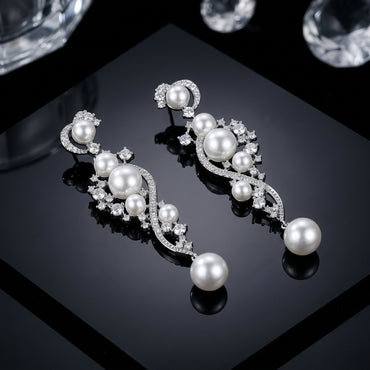 Silver-Tone Pearl & CZ Cascading Wave Long Drop Earrings product shot on dark reflective surface with crystals