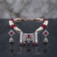 Silver Pearl CZ Mughal Scroll Jali Choker and Jhumka Earrings Set detail flat lay shot showing multi-strand pearl choker with Mughal arabesque jali CZ pave pendant and hanging jhumka drops on dark marble surface