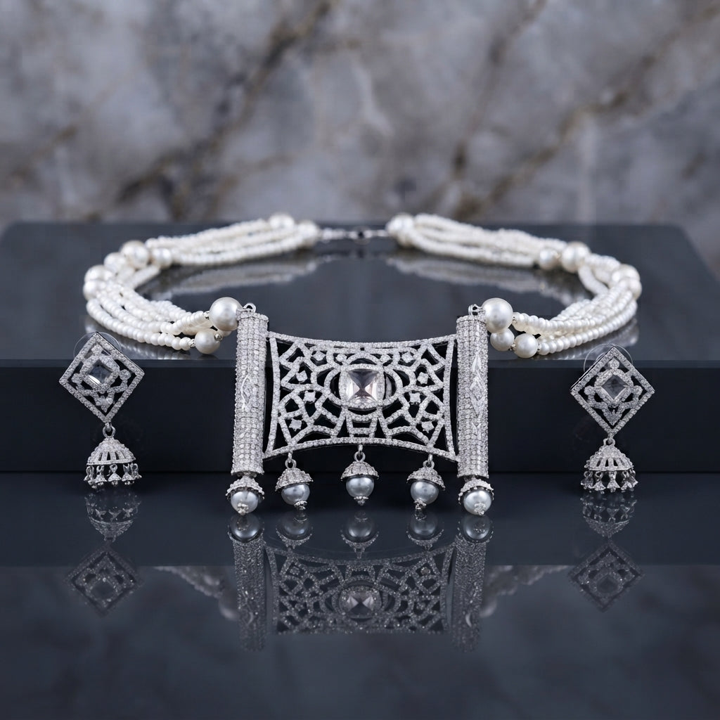 Silver Pearl CZ Mughal Scroll Jali Choker and Jhumka Earrings Set in Blush Pink on dark grey silk backdrop showing multi-strand white and pink pearl choker with wide rectangular Mughal arabesque jali CZ pave pendant with soft pink rose quartz cabochon centre and 3 hanging jhumka drops with pink bead finials and matching diamond-shape CZ jhumka earrings with mirror reflection below