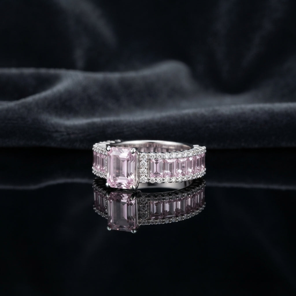 Silver CZ Statement Cocktail Ring in Pink Morganite — emerald-cut blush pink morganite CZ center with channel-set pink baguette eternity band and double white CZ pavé rows on dark silk backdrop
