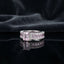Silver CZ Statement Cocktail Ring in Pink Morganite — emerald-cut blush pink morganite CZ center with channel-set pink baguette eternity band and double white CZ pavé rows on dark silk backdrop