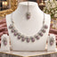 Silver Pink CZ Teardrop Cluster and White CZ Bow Floral Necklace Earrings Set worn by model in dusty pink mauve net lehenga showing 7-drop graduating collar necklace with pink CZ micro-pavé teardrop bodies and white CZ bow connectors with matching drop earrings in warm bokeh editorial setting