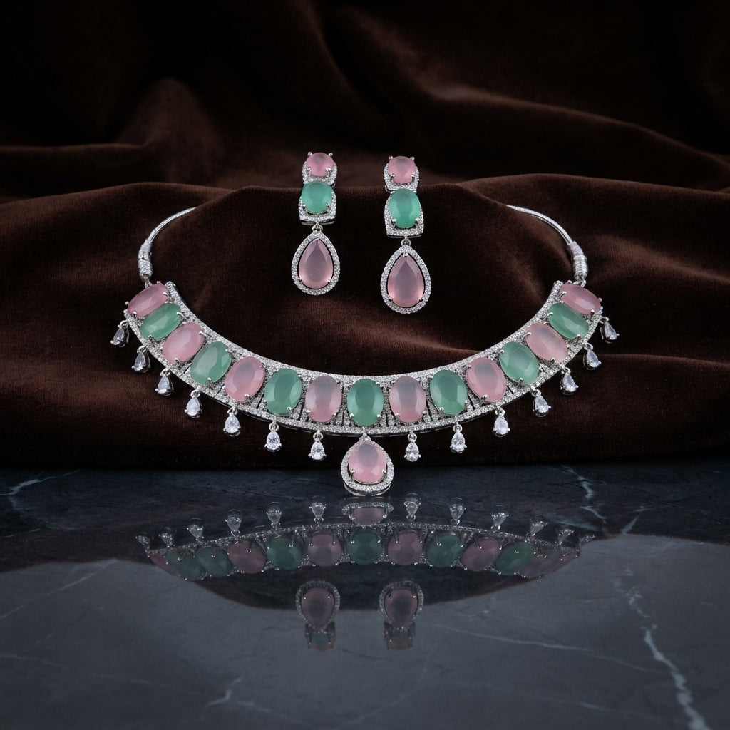 Silver Pink & Mint Green Cabochon CZ Torque Necklace & Drop Earrings Bridal Set on dark grey marble surface with dark brown velvet drape backdrop
