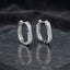 Gold-tone rounded-rectangle hoop earrings with pavé-style clear stones.