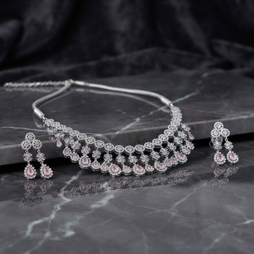 Silver Rose Pink CZ Floral Fringe Collar Necklace and Chandelier Earrings Bridal Set — rhodium silver-tone 2-piece bridal set with continuous round CZ halo station collar necklace with 5-petal CZ flower connectors and rose pink pear CZ fringe drops and matching 3-drop chandelier earrings with round CZ halo stud and rose pink pear CZ drops displayed on grey marble surface with dark satin backdrop
