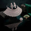 Silver-Tone Rose Quartz Pink Cushion Oval CZ Pavé Wide Tiered Mughal Bib Choker Necklace Chandelier Earrings Maang Tikka & Ring 4-Piece Bridal Set styled on dark stone surface with green velvet drape and jade fan backdrop