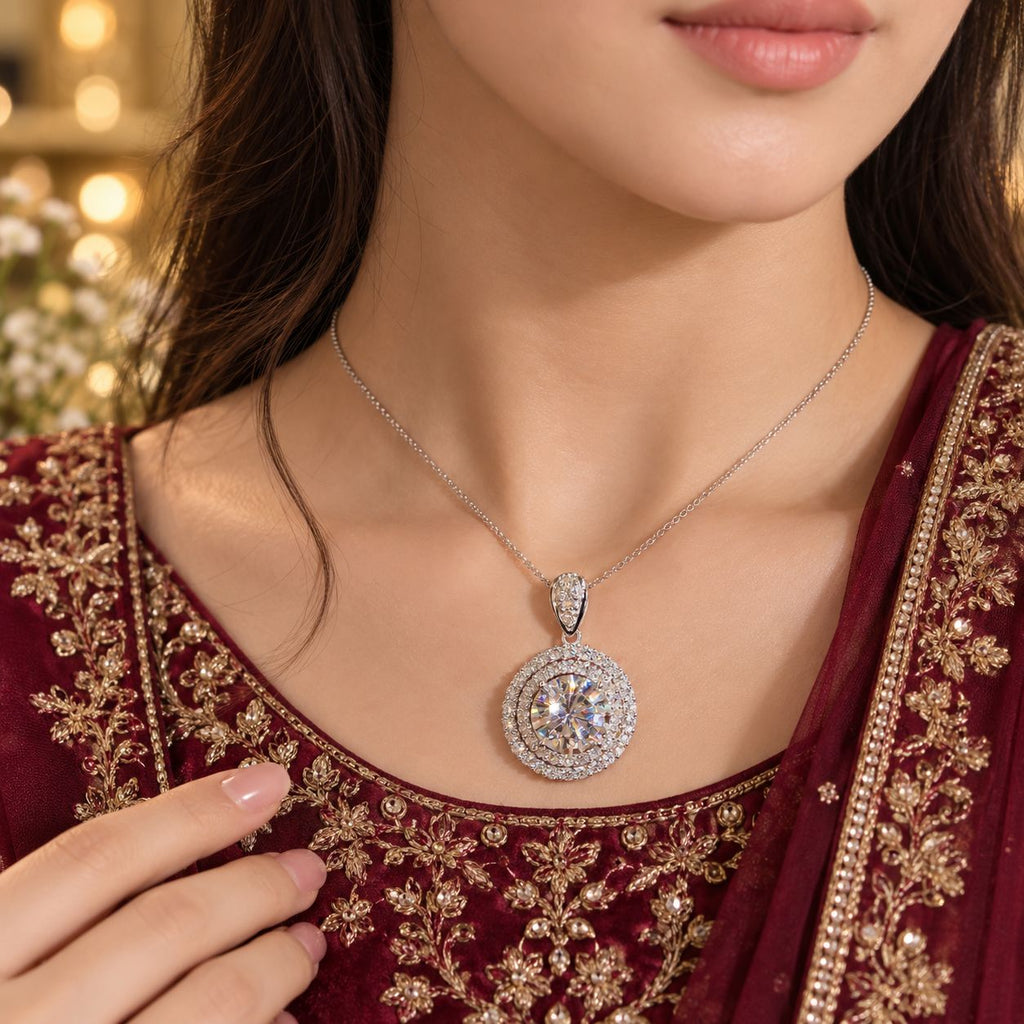 Silver Round CZ Double Halo Solitaire Pendant Bridal Necklace worn by bridal model in deep red embroidered lehenga with gold bokeh backdrop