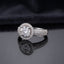 Silver Round CZ Solitaire Double Halo Triple Pave Split Shank Engagement Ring worn on ring finger of female model in navy blue blazer and white top in luxury jewelry boutique backdrop showing large round brilliant clear CZ solitaire with double round white CZ halo and triple-row micro-pave split shank band in rhodium silver