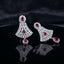 Silver Ruby CZ Floral Fan and Pear Halo Drop Earrings — rhodium silver-tone statement bridal earrings with ruby CZ oval daisy floral stud wide fan body in dense interlocking white CZ cluster honeycomb with ruby CZ center oval and large ruby CZ pear halo drop displayed on dark black mirror surface with charcoal satin backdrop