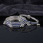 Silver Sapphire Blue CZ Eternity Band Ghungroo Charm Bangle Set of 4 spread shot showing all 4 bangles fanned apart on dark grey matte surface with dark satin fabric backdrop each showing full continuous sapphire blue CZ eternity band with twisted rope silver borders and triple silver ghungroo bell charm drops at even intervals in rhodium silver