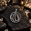 Silver-tone round Allah calligraphy pendant with clear accents, an openwork centre, curved loop details along one side and a ridged top bail.