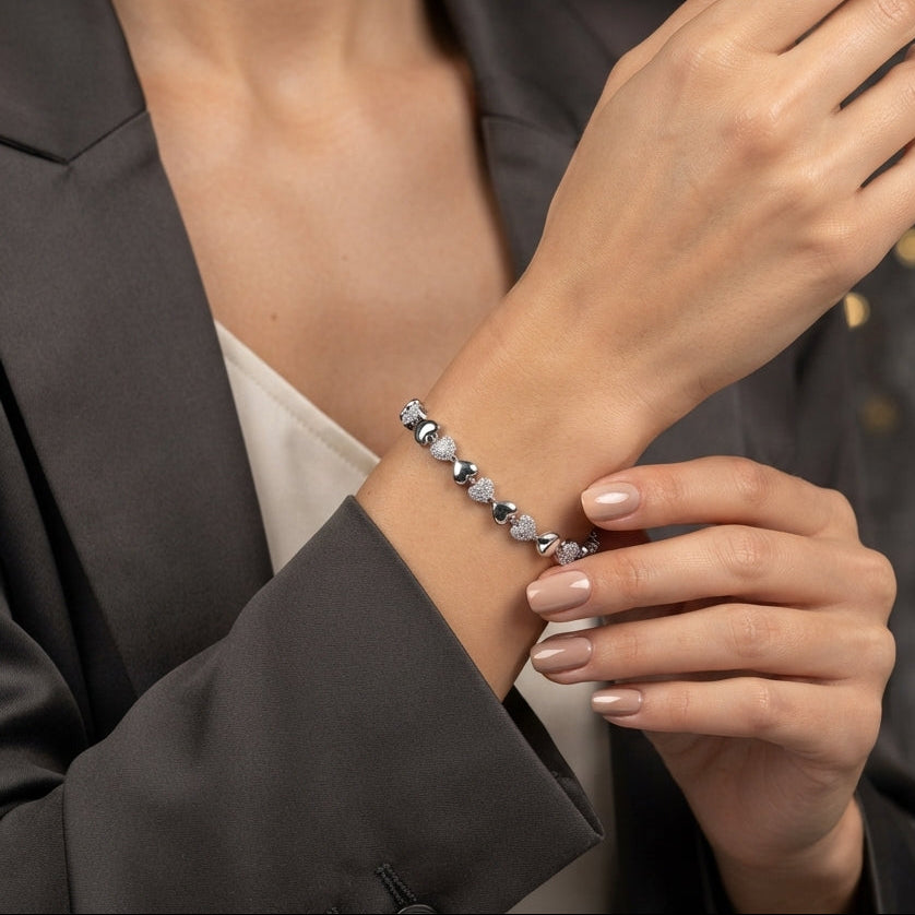 Silver-Tone Alternating CZ Pavé & Polished Heart Tennis Bracelet worn by model in grey blazer