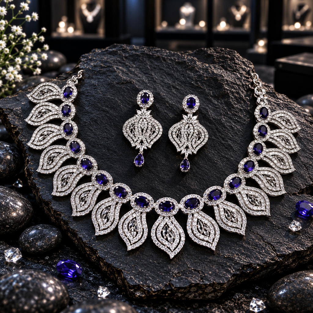 Silver-tone AD necklace with navy blue oval halo centres and pointed openwork leaf fringe, with matching teardrop-finish earrings.