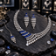 Silver-tone necklace, long tiered earrings and chain bindia with blue rectangular accents and cascading clear teardrop details.