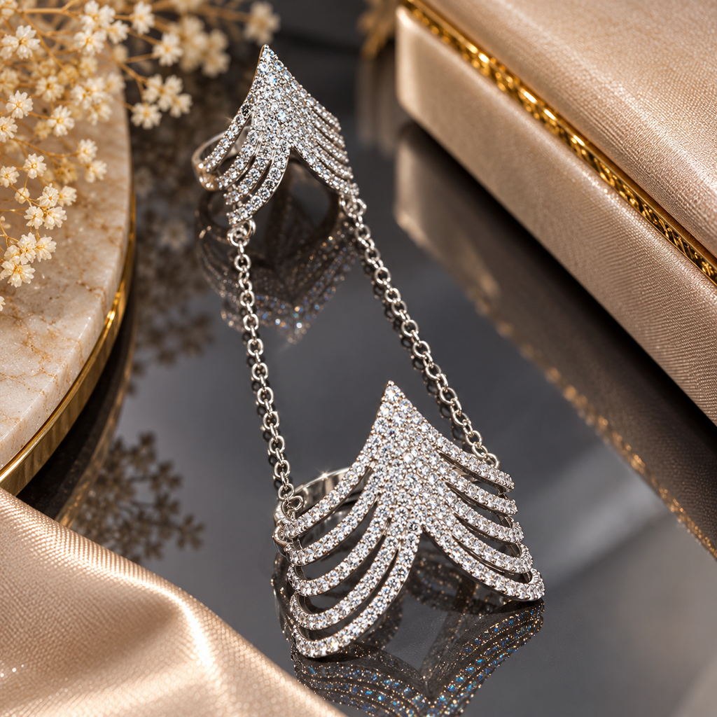 Silver-tone double finger ring with layered clear-accent chevron sections joined by two connecting chains.