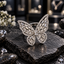 Silver-tone butterfly ring with clear rectangular and tapered wing accents, clear round borders and a clustered clear-looking centre.