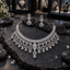 Silver-tone necklace with a narrow bar-style neckline, clear-looking leaf clusters and graduated teardrop fringe, alongside matching floral drop earrings.