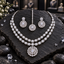 Silver-tone double-row oval halo necklace with a rounded openwork medallion pendant, matching medallion earrings and a single-strand bindia.