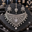 Silver-tone wide lattice choker-style necklace with floral scrollwork, a sunburst teardrop centre and hanging drops, with matching earrings and bindia.