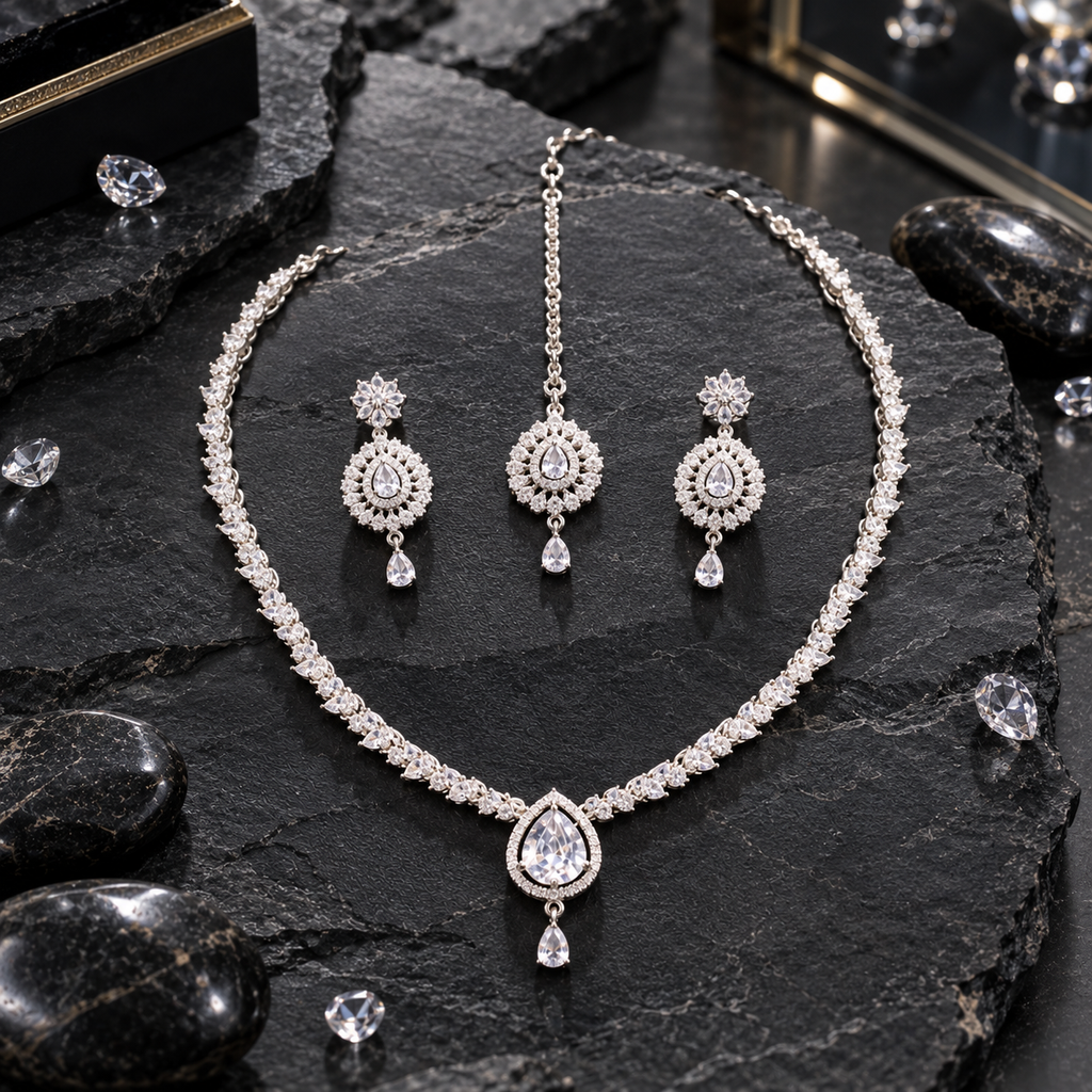 Silver-tone clear-looking leaf-link necklace with a halo-framed teardrop centre and small drop, with matching floral-top earrings and teardrop bindia.