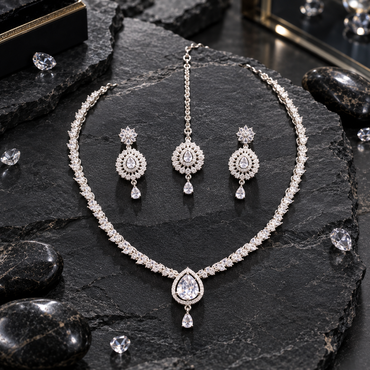 Silver-tone clear-looking leaf-link necklace with a halo-framed teardrop centre and small drop, with matching floral-top earrings and teardrop bindia.