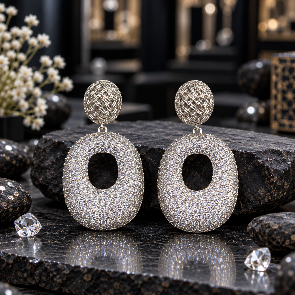 Silver-tone drop earrings with woven-look oval tops and broad clear-accent oval drops featuring open centres.