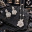 Silver-tone necklace and earrings set with clear-accent layered rose designs, leaf details and round clear accents spaced along the necklace chain.