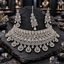 Silver-tone wide choker-style necklace with clear-looking rectangular and rounded halos, open teardrop fringe, matching elongated earrings and bindia.